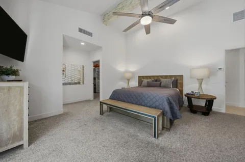 a spacious bedroom with a bed and a flat screen tv