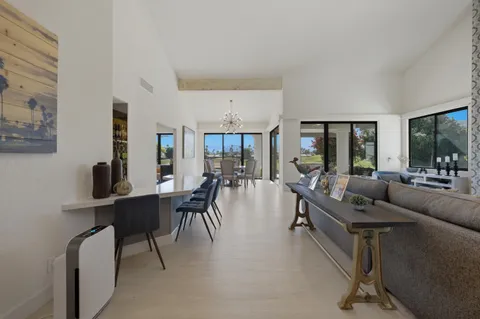a living room with furniture a dining table and a large window