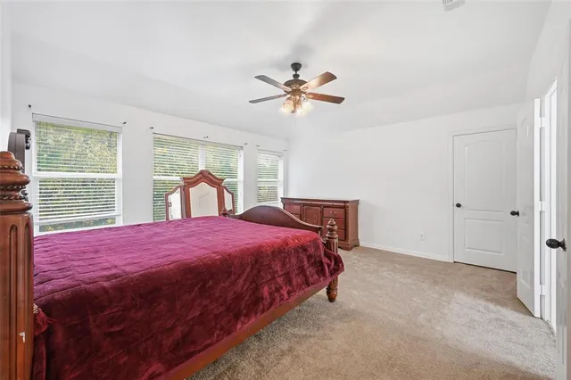 a bedroom with a bed dresser and a window