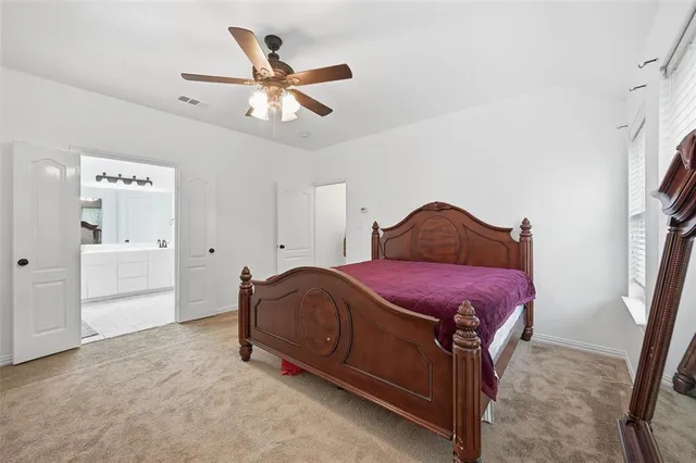 a spacious bedroom with a bed and a ceiling fan