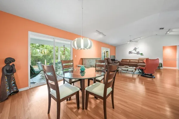 a kitchen with granite countertop a refrigerator a stove a sink cabinets and wooden floor