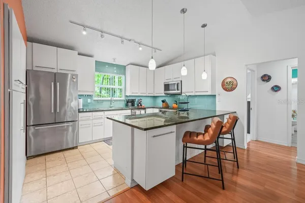 a spacious bedroom with a bed and a chandelier