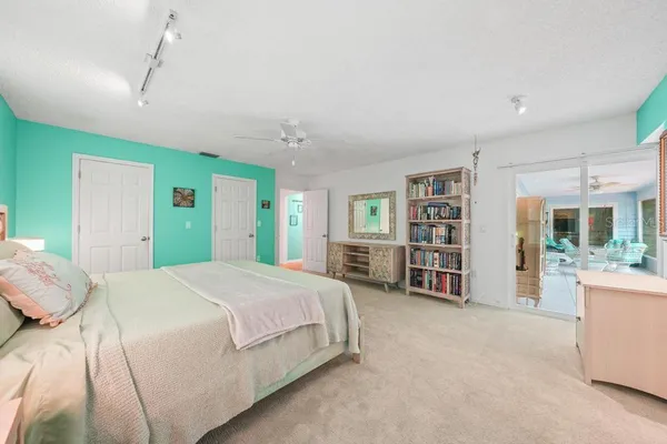 a bedroom with a bed chandelier and a window