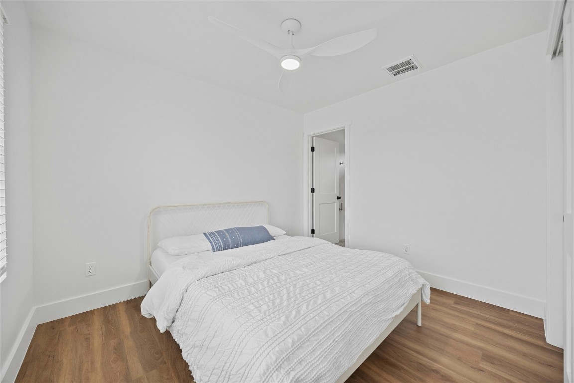 4704 Enchanted Lane, Unit B Austin, TX 78745 - Photo 16 of 23 a bedroom with a bed and wooden floor