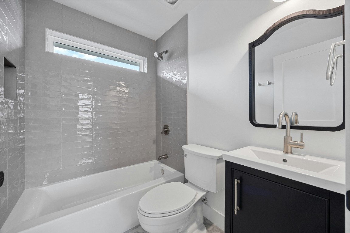 4704 Enchanted Lane, Unit B Austin, TX 78745 - Photo 18 of 23 a bathroom with a toilet a sink a mirror a bathtub and vanity