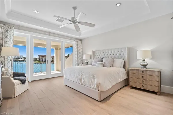 a spacious bedroom with a large bed and a chandelier