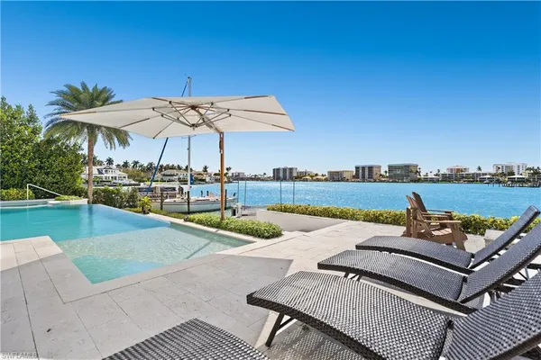an outdoor sitting area with furniture and umbrella