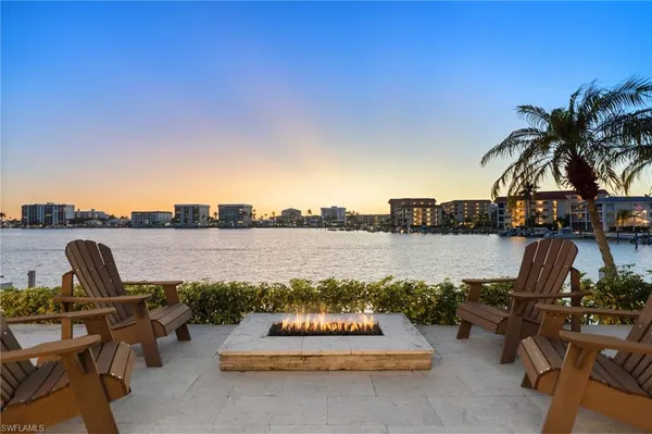 a view of a lake with outdoor seating and city view