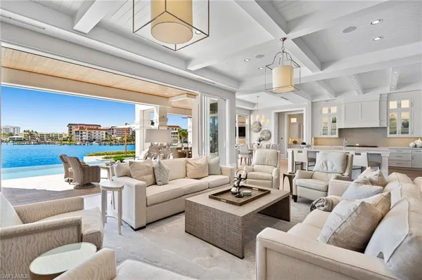 a living room with furniture kitchen view and a large window