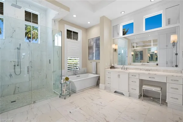 a spacious en suite bathroom with a granite countertop sink mirror and shower