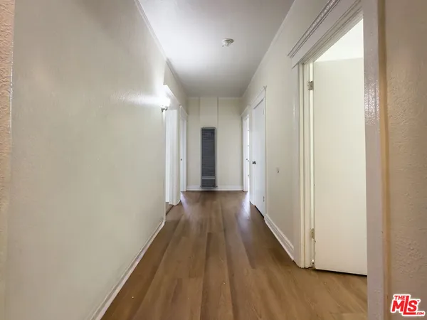 a view of a hallway with wooden floor