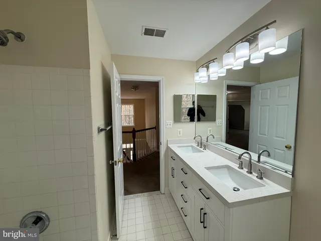 a bathroom with a double vanity sink and a mirror