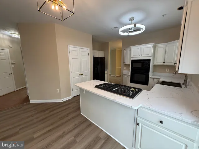 an empty room with wooden floor fireplace and windows
