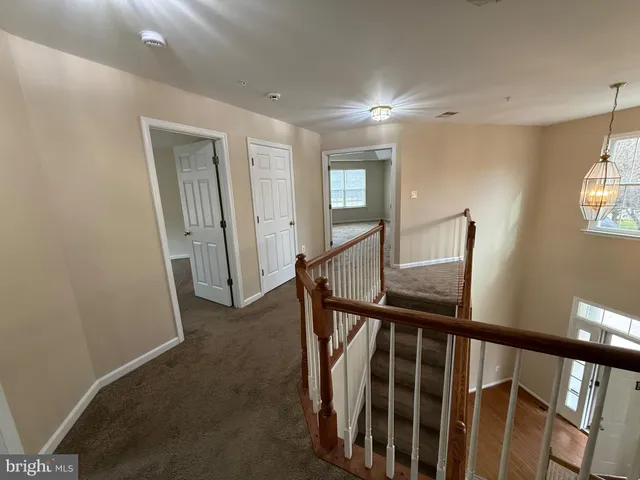 a view of staircase with wooden floor and fan