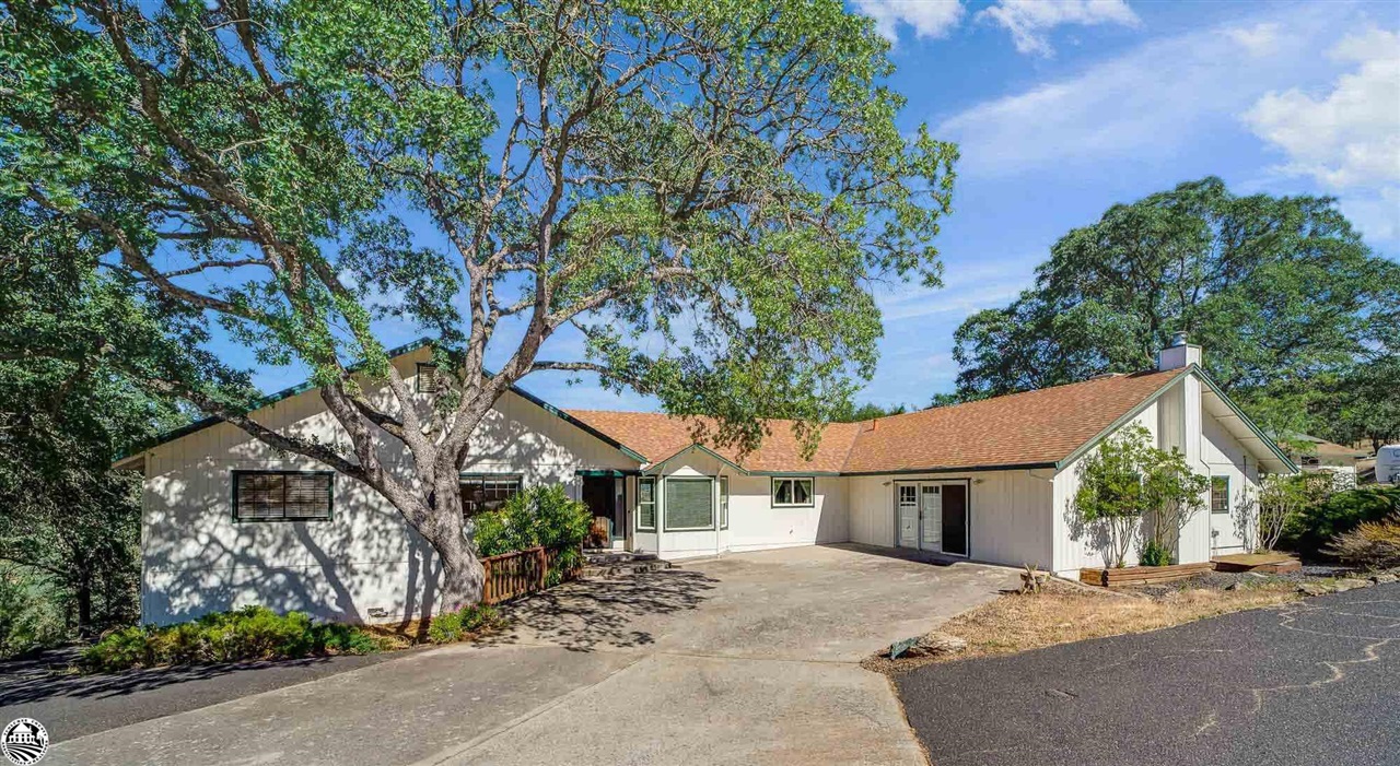 1801 Quail Hill Road Copperopolis, CA 95228 - Photo 1 of 42 a front view of a house with a garden and a tree