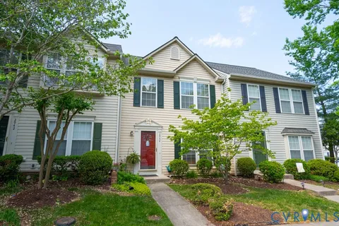 a front view of a house with a yard and potted plants