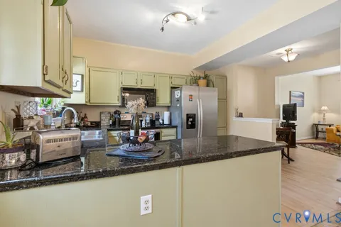a kitchen with stainless steel appliances granite countertop a sink a stove and a refrigerator