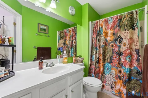 a bathroom with a sink mirror vanity and toilet