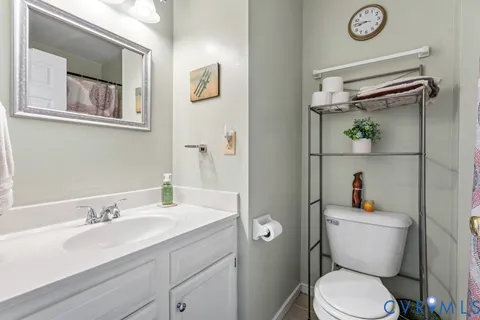 a bathroom with a toilet a sink and mirror