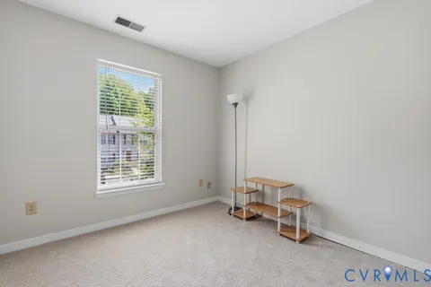 an empty room with a chair and a window