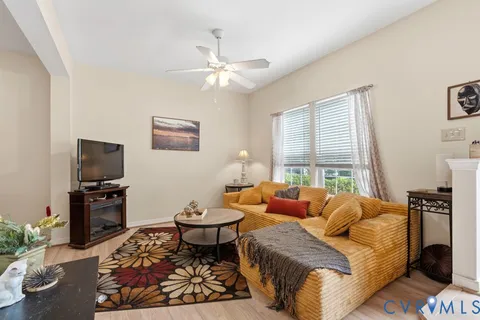 a living room with furniture a flat screen tv and a large window