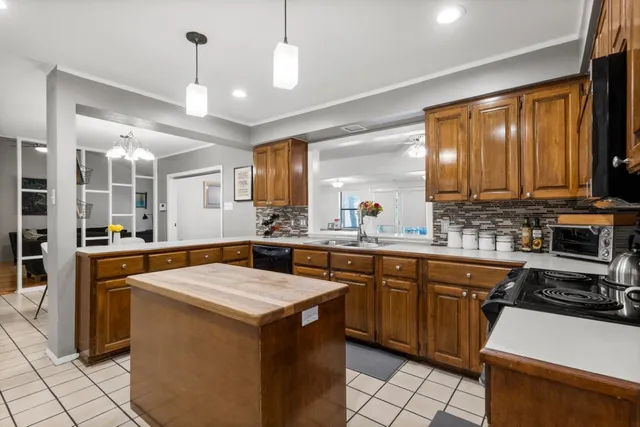 a kitchen that has a sink a stove and chairs