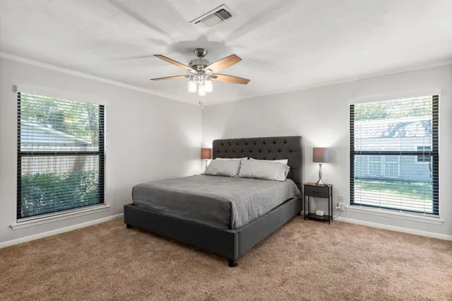 a spacious bedroom with a bed and a large window