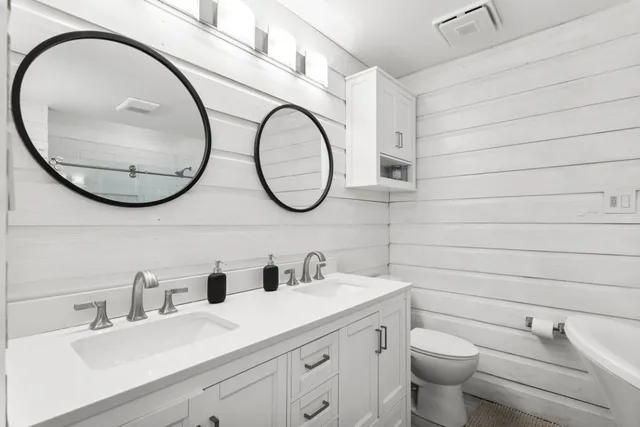 a bathroom with a toilet a sink and a mirror
