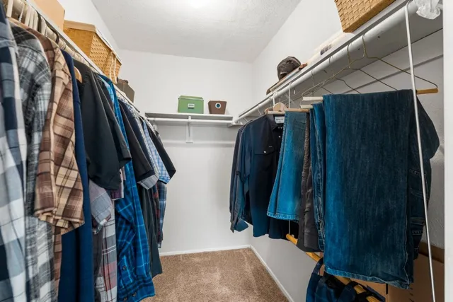 a view of walk in closet with clothes