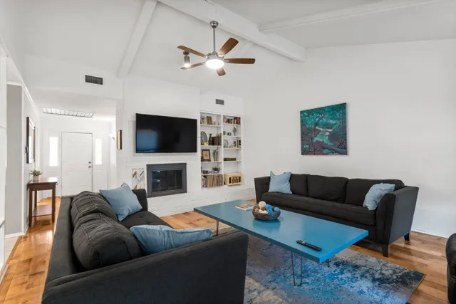 a living room with furniture a fireplace and a flat screen tv
