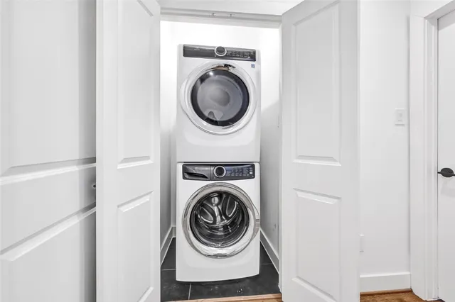 an empty room with wooden floor chandelier fan and windows