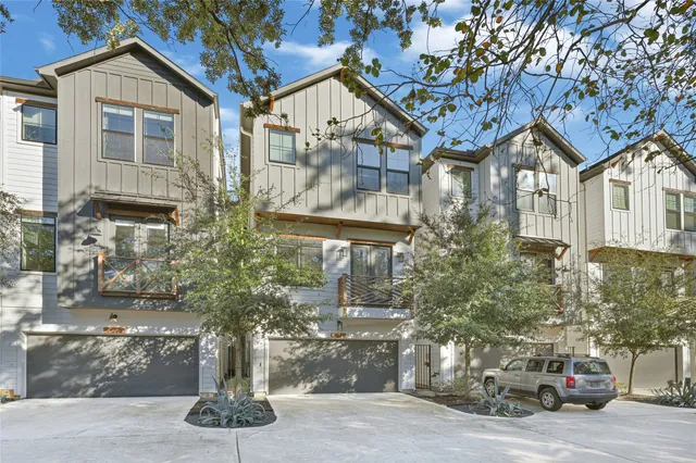 a aerial view of a house with yard and trees in the background