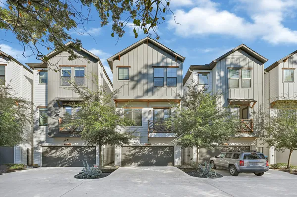 an aerial view of residential houses with outdoor space and trees