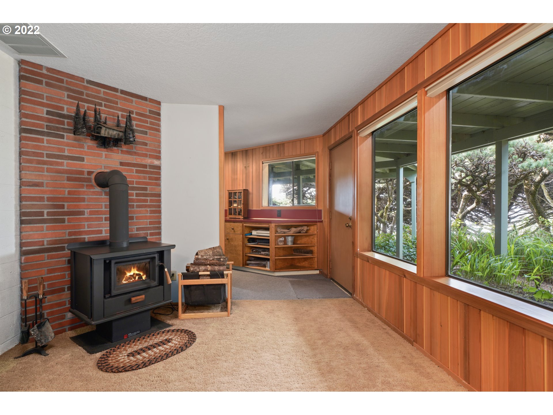 8125 Neahkahnie Road Nehalem, OR 97131 - Photo 25 of 32 a living room with furniture windows and a fireplace