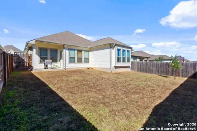 a front view of a house with a yard and potted plants