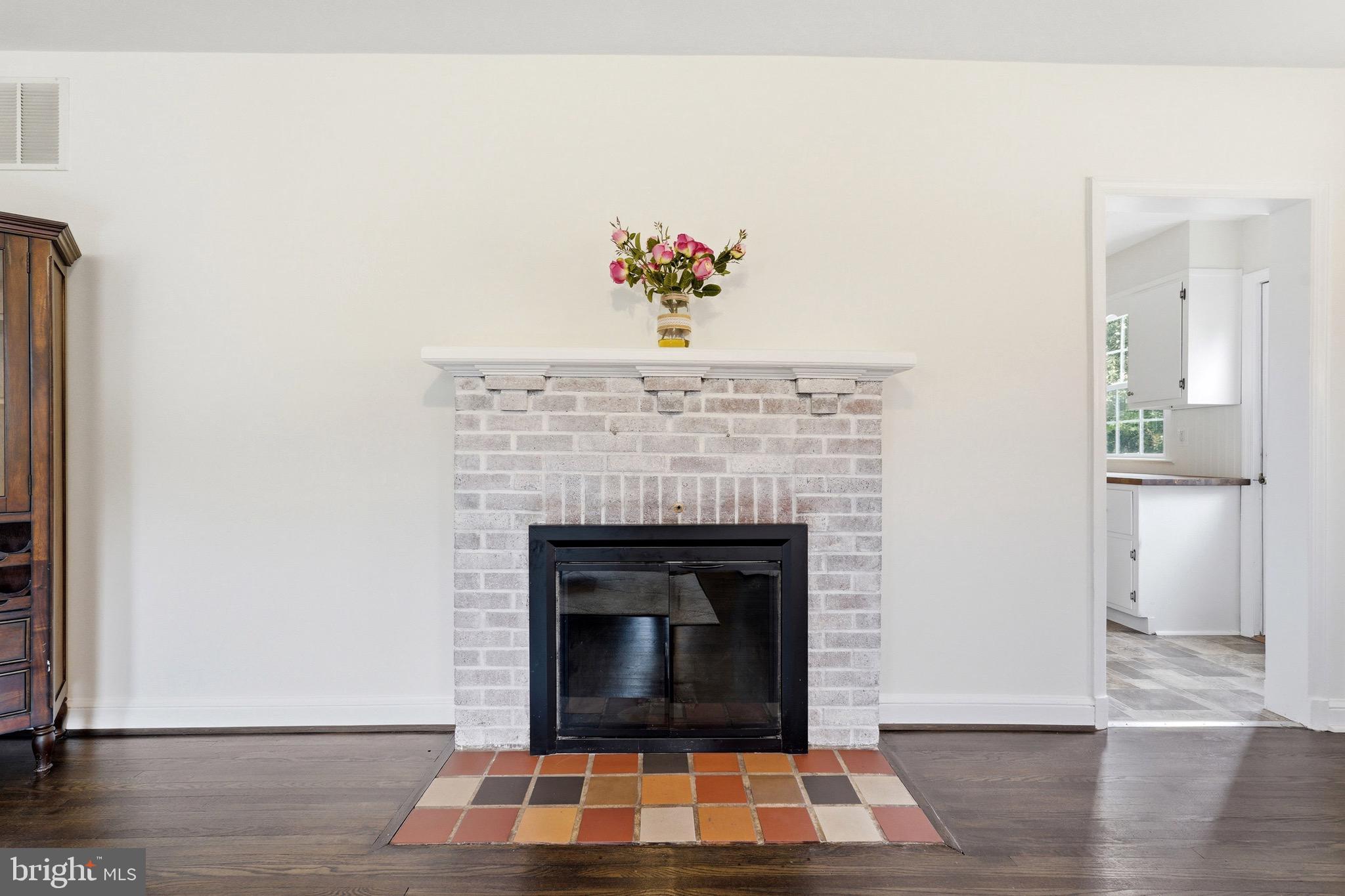 23725 Woodfield Road Gaithersburg, MD 20882 - Photo 12 of 61 a living room with a fireplace and a wooden floor