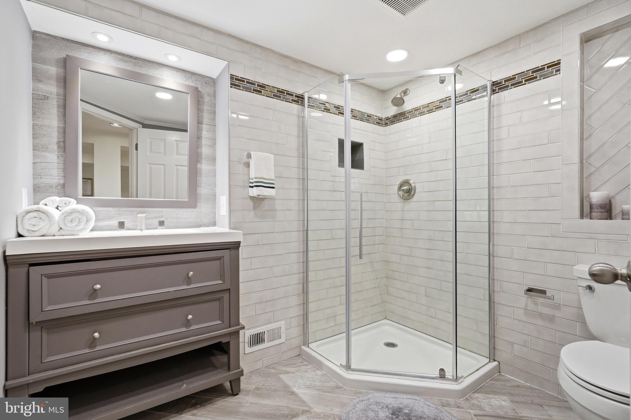 23725 Woodfield Road Gaithersburg, MD 20882 - Photo 30 of 61 a bathroom with a shower sink mirror and toilet