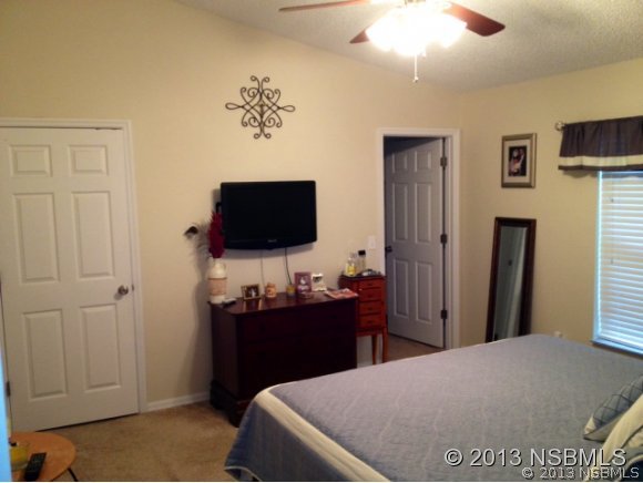 3224 Mango Tree Drive Edgewater, FL 32141 - Photo 15 of 17 a bedroom with a bed and a flat screen tv