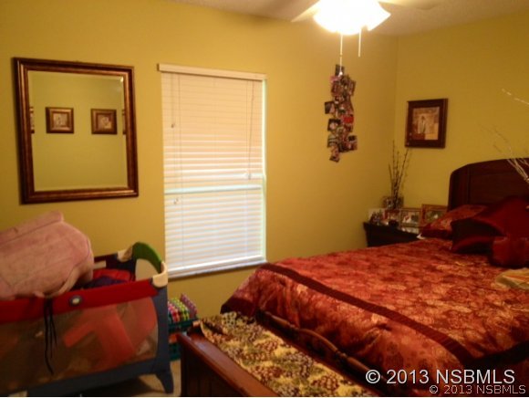 3224 Mango Tree Drive Edgewater, FL 32141 - Photo 10 of 17 a bed sitting in a bedroom next to a window