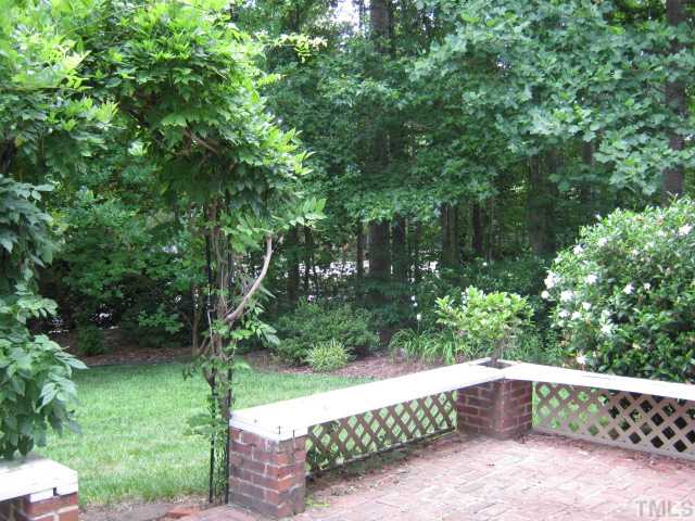 5816 Edgebury Road Raleigh, NC 27613 - Photo 11 of 12 Back yard features brick patio with built-in seating, planting areas, arbor with wisteria growing up and over! This is great outdoor living and entertaining space!