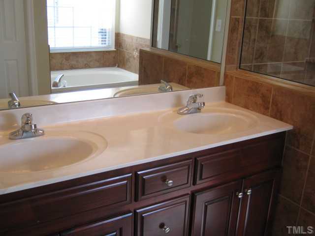 5816 Edgebury Road Raleigh, NC 27613 - Photo 3 of 12 Master bath features tile floor, new tile shower and enclosure, garden tub, new double sink vanity with cultured marble top, new faucets, custom tile work, separate water closet!