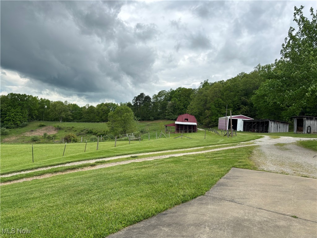 212 Rost Road Walker, WV 26180 - Photo 2 of 29 View of yard featuring gravel driveway, an outdoor structure, an outbuilding, and a wooded view