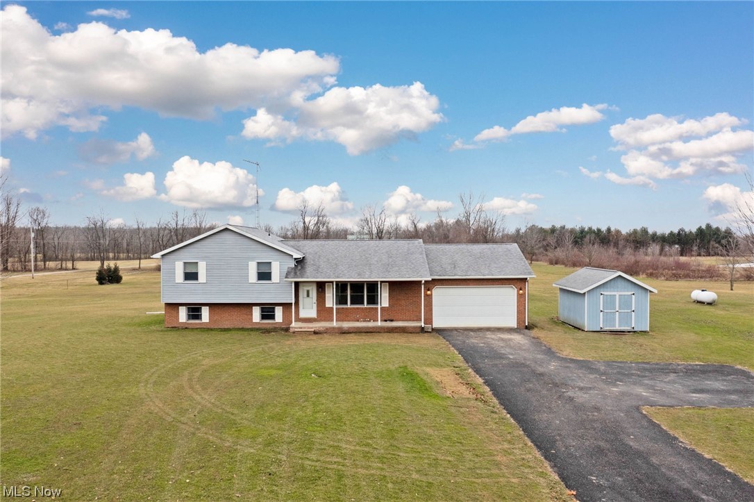 411 Adario West Road Shiloh, OH 44878 - Photo 27 of 35 Tri-level home featuring a front lawn, a storage shed, and a garage