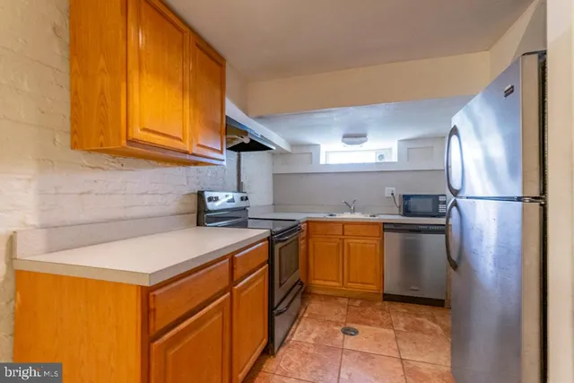 a kitchen with stainless steel appliances granite countertop a sink refrigerator and cabinets