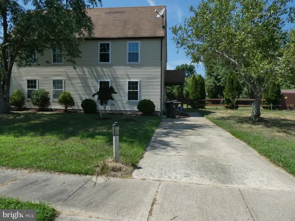 a front view of a house with a yard and trees