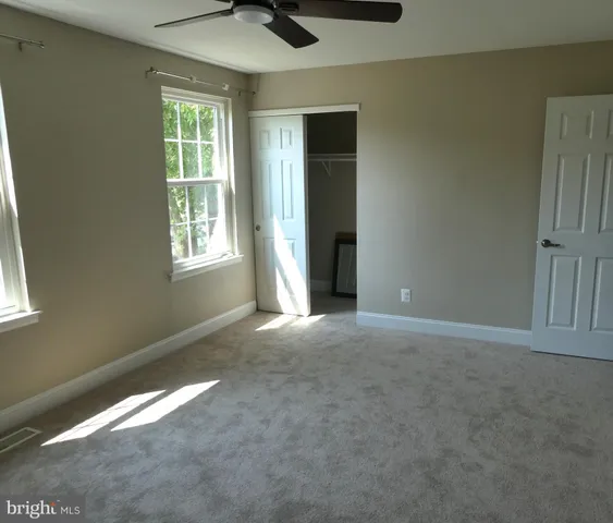 an empty room with windows and closet