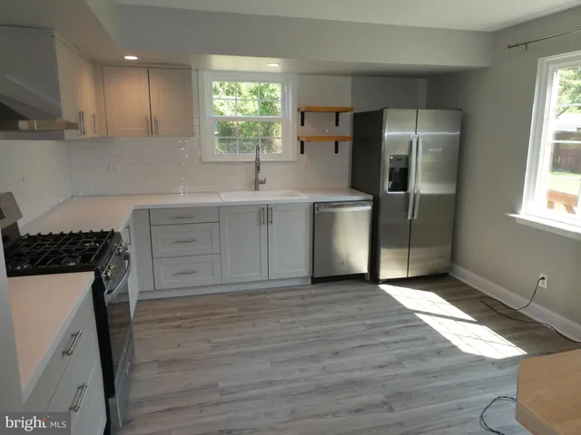 a kitchen with stainless steel appliances a refrigerator sink and stove