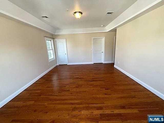 315 Frank E Rodgers Boulevard North, Unit 3 Harrison, NJ 07029 - Photo 12 of 18 a view of an empty room with wooden floor and a window