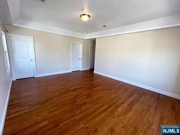 a view of an empty room with wooden floor