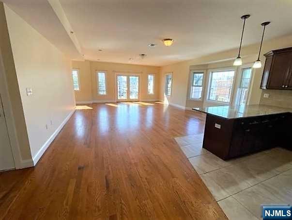 315 Frank E Rodgers Boulevard North, Unit 3 Harrison, NJ 07029 - Photo 2 of 18 a view of a room with wooden floor and windows
